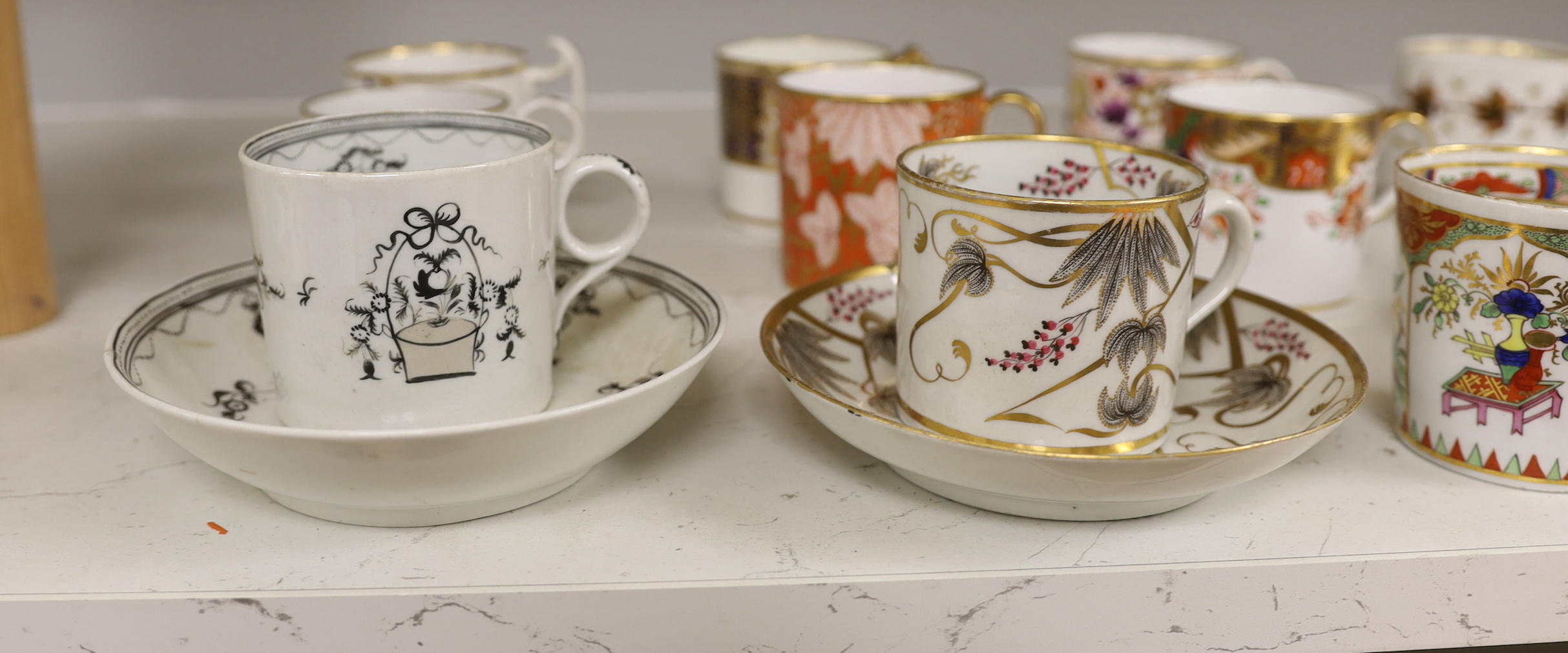 English porcelain coffee cans including Worcester, Spode, Wolfe Mason, Derby and Chamberlain, two New hall cans and saucers and a New hall Warburton’s Patent saucer dish, the largest 20cm in diameter